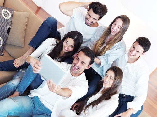 skupina of friends taking selfie photo with tablet at modern home indoors